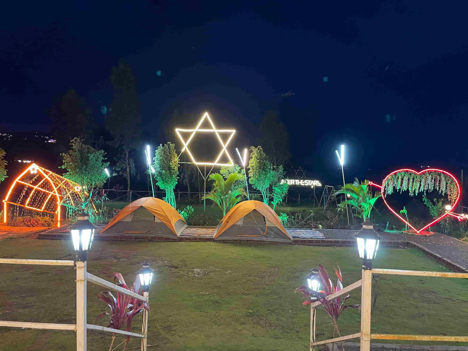 Tents and fairy lights on the lawn at night