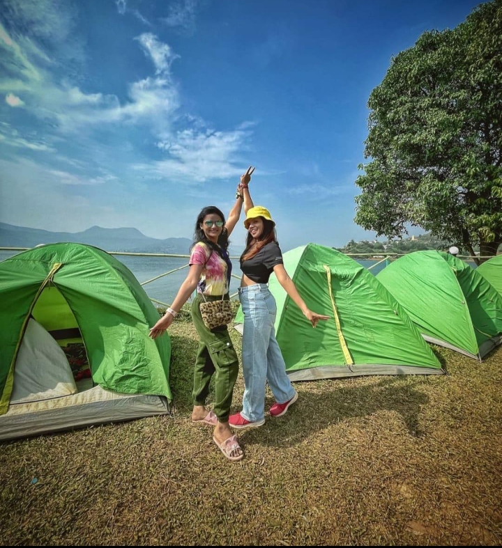 Campers posing in front of green tents at Pawna Machi