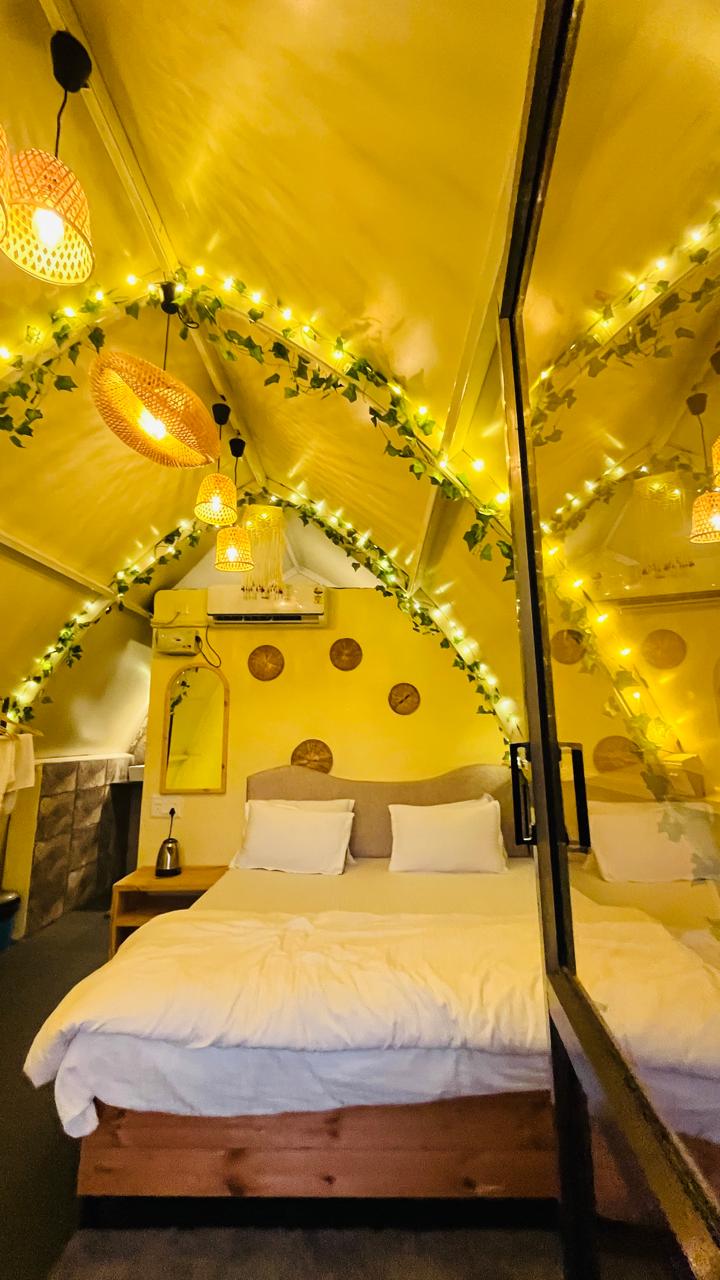 Double bed under the arched roof with ivy and fairy lights